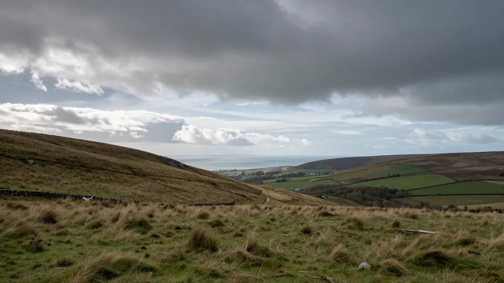 distant hillside with distant UK coastline under dramatic sky