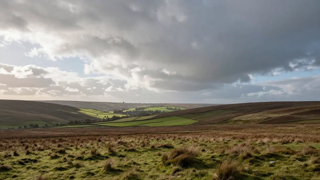 Expansive rolling countryside moorland under dramatic skies, distant town silhouette on horizon