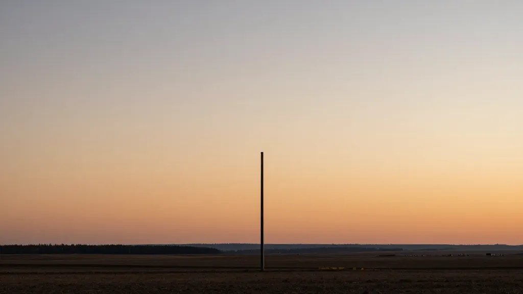 Distant landscape of a tall party wall boundary marker at sunset
