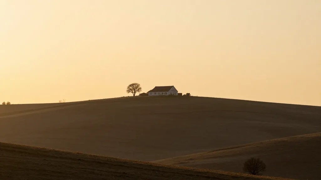 Distant hillside farmhouse at golden hour, minimal trees
