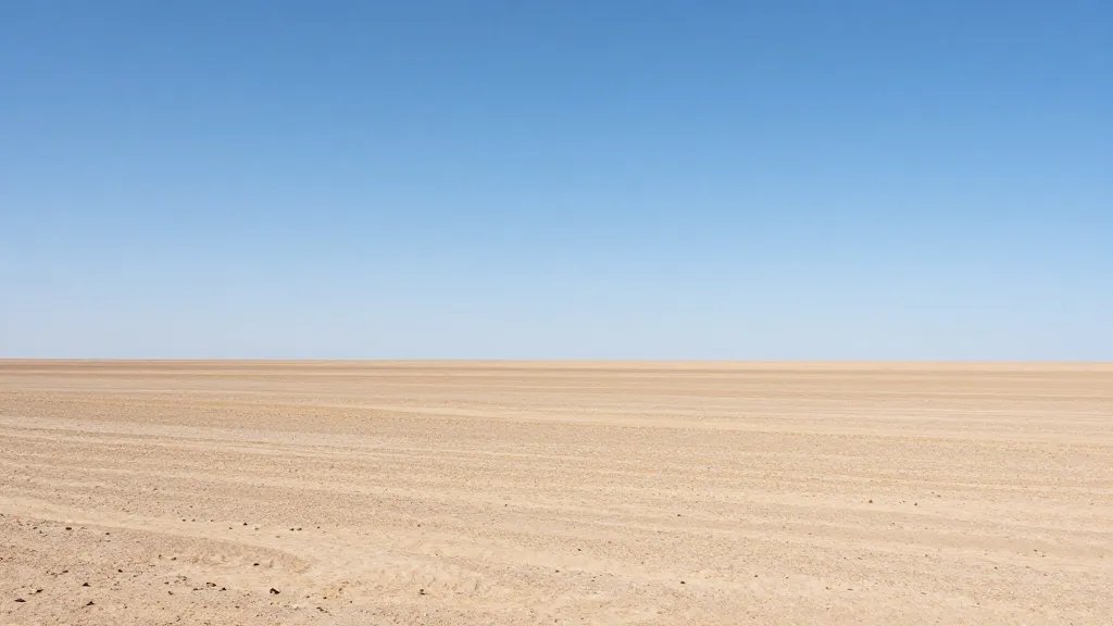Expansive desert plateau under a clear blue sky, distant horizon line