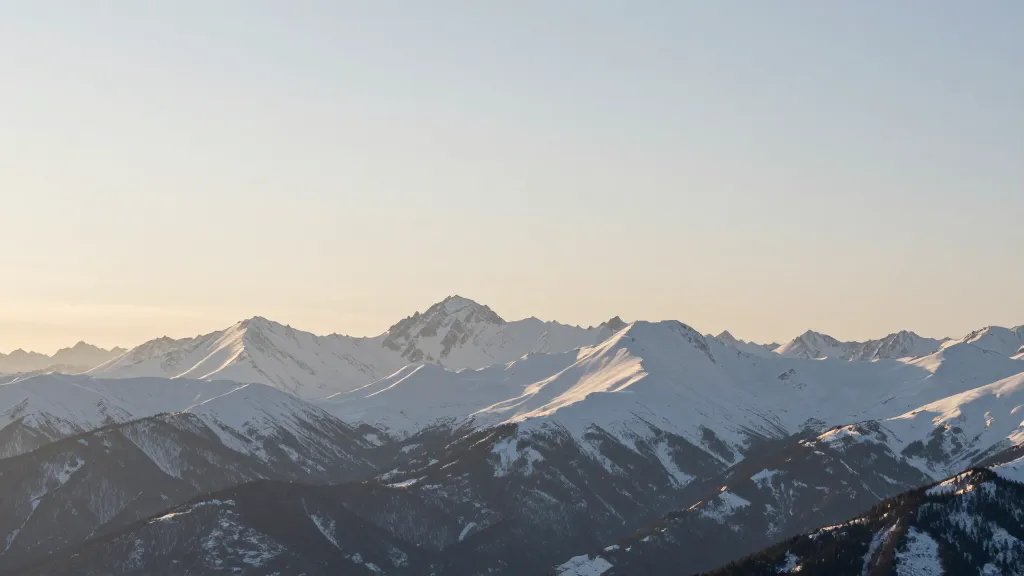 Distant landscape of snow-covered mountains with soft morning light