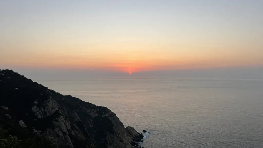 Distant coastal clifftop overlooking a calm sea at sunset