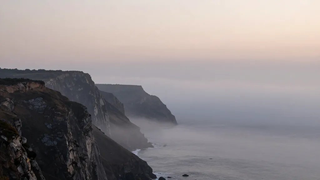 Distant view of misty coastal cliffs at dawn, offset mortgage concept in quiet horizon
