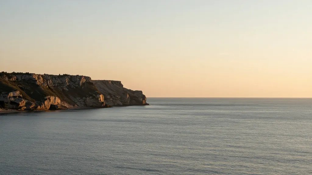 Distant view of a single calm coastal cliff at golden hour