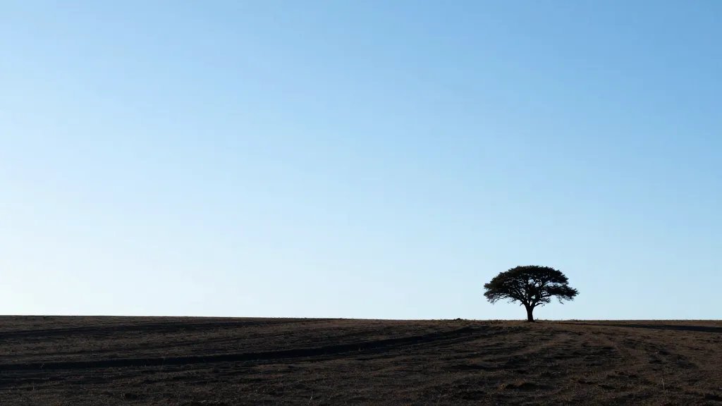 Open plains with lone tree silhouettes, expansive horizon under clear blue sky