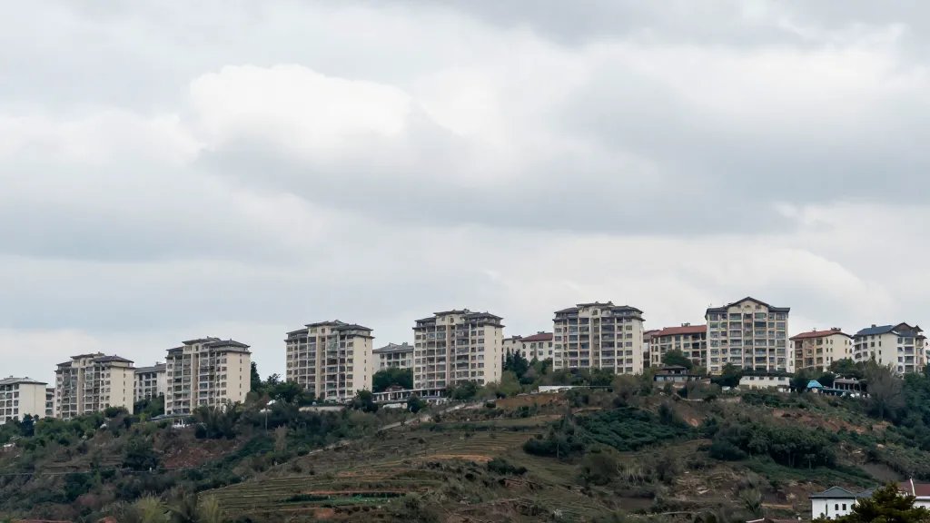 Panoramic hillside apartment complex from afar against a cloudy horizon