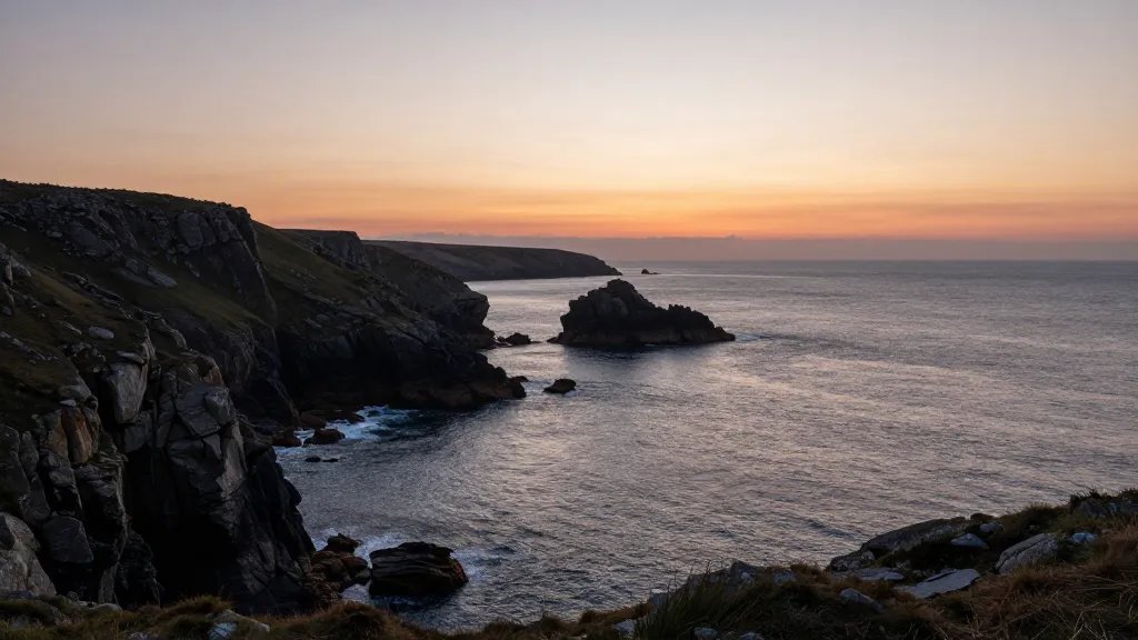 Wide sea horizon over rugged headland, sunset, Cornwall