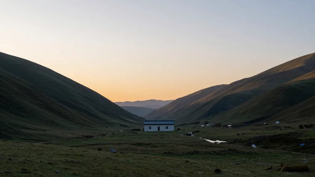 Wide valley view from a hill, single rental building centered, soft sunrise light