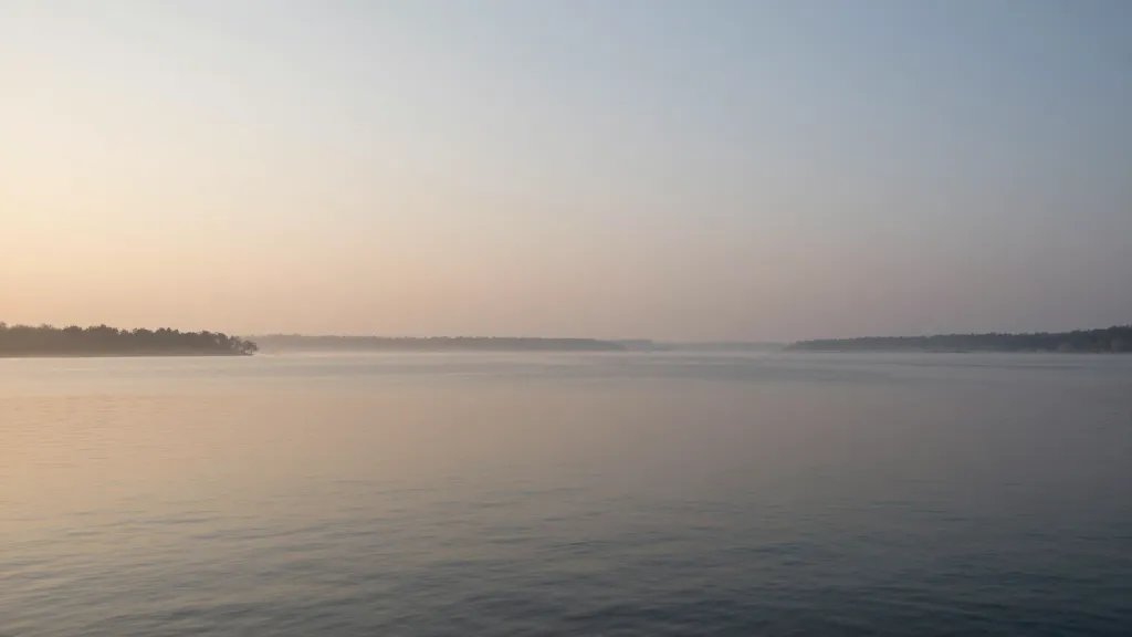 Distant lake landscape at dawn, soft light hinting at security and protection over water