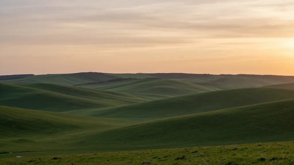 Distant landscape of a rolling-green countryside valley at sunset