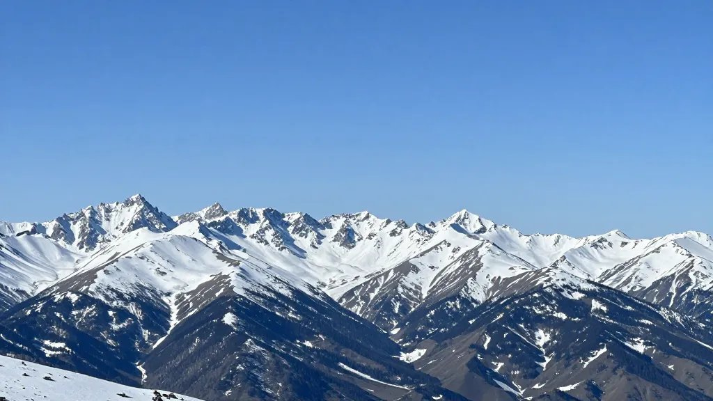 Distant landscape of a snow-capped mountain range under clear blue sky