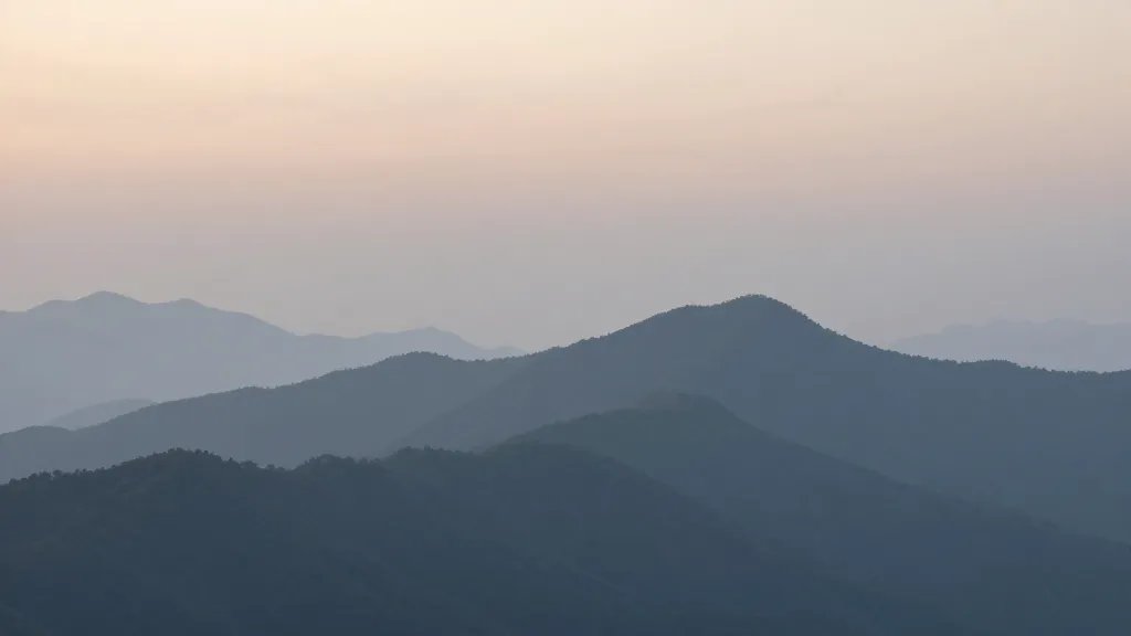 distant landscape of misty mountain ridge at dawn