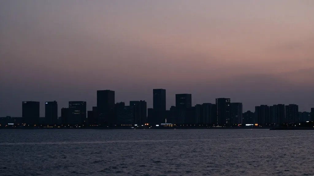 Distant coastal town skyline at dusk, planning office silhouettes on horizon