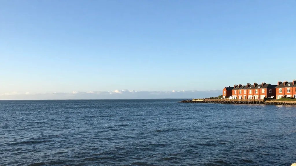 Expansive coastline view with a lone red brick buy-to-let townhouse on the horizon